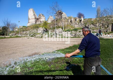 Fatih,Istanbul,Turquie - 04-02-2017:vue des murs byzantins historiques avec un fermier travaillant dans le champ de légumes Banque D'Images