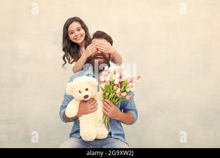 Devinez qui. Bonne fille vêtements pères yeux avec les mains. Jeu de devinettes. Surprise d'anniversaire. Cadeau surprise. Boutique de fleurs. Toyshop. Bonne famille Banque D'Images