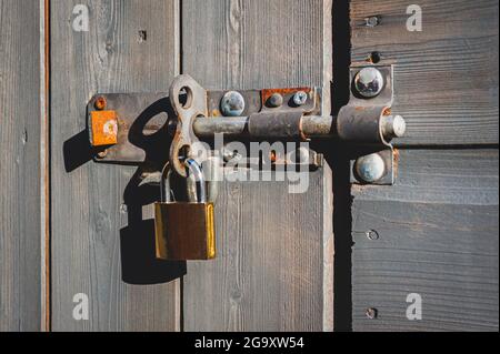 Cadenas en laiton avec verrou à boulon sur porte en bois. Banque D'Images