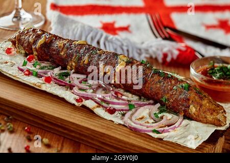 Kebab de bœuf et de fromage avec lavash, oignon, graines de grenade et satsebeli dans le restaurant géorgien Banque D'Images