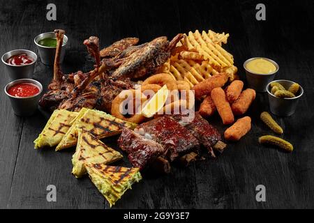 Ensemble de bière de côtes de porc, poulet, poisson frit, bâtonnets de fromage, rondelles d'oignon, frites et burritos Banque D'Images