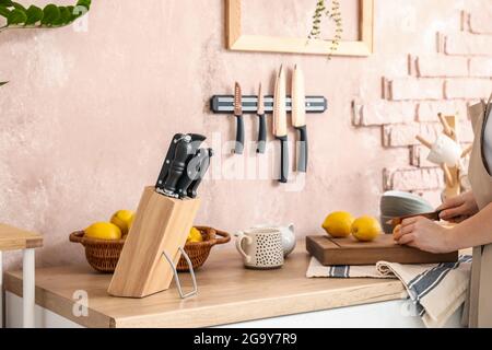 Femme coupant le citron dans la cuisine Banque D'Images