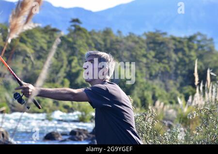 Homme debout près d'une rivière de pêche, Argentine Banque D'Images