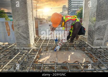 Travailleur de la construction sur un chantier de vérification des fondations, Thaïlande Banque D'Images