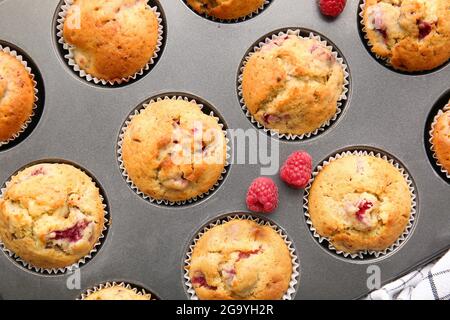 Moule à pâtisserie avec muffins savoureux à la framboise, gros plan Banque D'Images