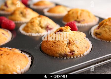 Moule à pâtisserie avec muffins savoureux à la framboise, gros plan Banque D'Images