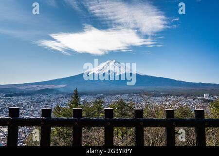 Cirrostratus nuages au-dessus de la montagne Fuji avec clôture en bois en premier plan à partir du sommet du parc Arakurayama Sengen, Japon. Banque D'Images