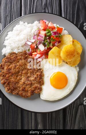 Le Silpancho est un incroyable repas bolivien fait de riz et est recouvert d'un hamburger poêlé, de salsa, de pommes de terre frites, et d'oeuf closeup dans l'assiette de TH Banque D'Images