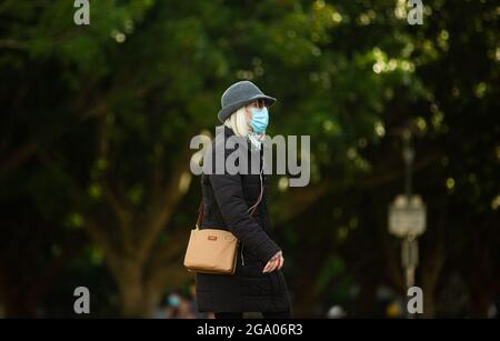 Sydney, Australie. 28 juillet 2021. Une femme marche dans une rue vide à Sydney, en Australie, le 28 juillet 2021. Alors que le nombre de cas quotidiens dans l'État australien de Nouvelle-Galles du Sud (NSW) a continué de flotter à trois chiffres, le gouvernement de l'État a annoncé mercredi une prolongation de quatre semaines du confinement dans le Grand Sydney et les régions environnantes. Credit: Hu Jingchen/Xinhua/Alay Live News Banque D'Images