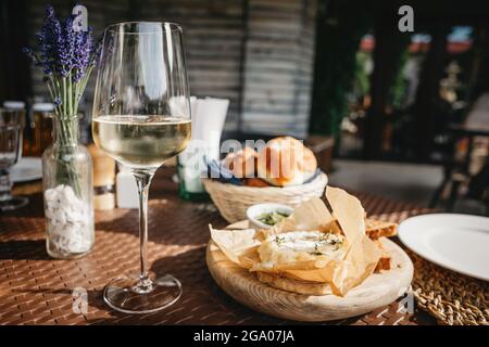 Verre de vin blanc froid et fromage camembert cuit au four Banque D'Images