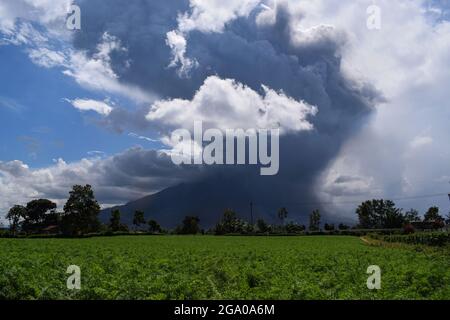 (210728) -- SUMATRA DU NORD, 28 juillet 2021 (Xinhua) -- photo prise le 28 juillet 2021 montre le Mont Sinabung crachant des matériaux volcaniques et de la fumée comme vu de Tima Pancur à Karo, Sumatra du Nord, Indonésie. (Photo de Sarianto Sembiring/Xinhua) Banque D'Images