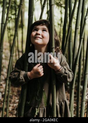 ENFANT SAUVAGE PARMI LE BAMBOU DANS LA NATURE Banque D'Images