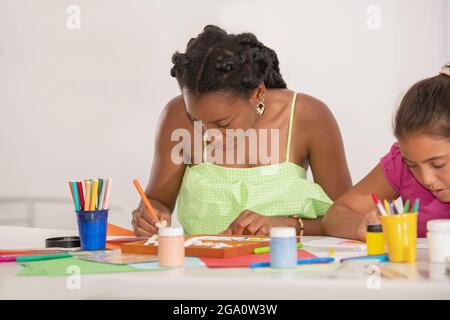 Enseignant aidant l'élève à dessiner dans l'activité scolaire Banque D'Images