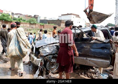 (210728) -- ISLAMABAD, le 28 juillet 2021 (Xinhua) -- les gens examinent un véhicule endommagé après de fortes pluies à Islamabad, capitale du Pakistan, le 28 juillet 2021. Les autorités pakistanaises ont déclaré mercredi que de fortes pluies ont fait des ravages dans la capitale fédérale du pays, Islamabad, tuant au moins deux personnes et en blessant plusieurs autres.POUR ALLER AVEC « Roundup : de fortes pluies ont fait des ravages dans la capitale du Pakistan » (Xinhua/Ahmad Kamal) Banque D'Images