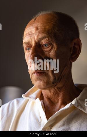 Peintre ou artiste mature ou senior avec crayon graphite devant l'appareil photo. Homme dans une chemise colorée à la peinture travaillant au studio Banque D'Images