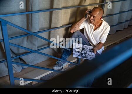 Peintre ou artiste mature ou senior avec crayon graphite devant l'appareil photo. Homme dans une chemise colorée à la peinture travaillant au studio Banque D'Images
