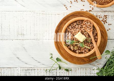 Porridge de sarrasin dans un bol avec feuille de persil et beurre sur fond de bois blanc ancien. Plats faits maison. Grains anciens sans gluten pour une alimentation saine. Haut Banque D'Images