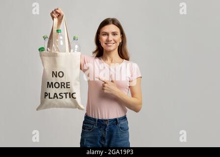 Concept d'éco-activisme. Une femelle pointe vers un sac fourre-tout sans inscription en plastique Banque D'Images