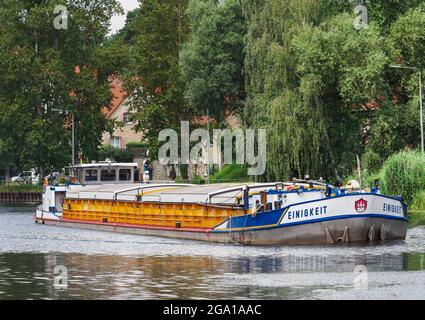 Kleinmachnow, Allemagne. 22 juillet 2021. La barge 'MS EINIGKEIT' (Hambourg) quitte l'écluse de Kleinmachnower dans le canal de Teltow. Le canal de Teltow s'étend sur environ 38 kilomètres à travers le Brandebourg et Berlin et est un important contournement sud de Berlin pour la navigation commerciale et une destination populaire pour les campeurs, les touristes de bateau et aussi les randonneurs. À Dreilinden, par exemple, il y a des voies plus ou moins étroites pour les piétons près de la rive du canal jusqu'à Machnower See. Credit: Soeren Stache/dpa-Zentralbild/ZB/dpa/Alay Live News Banque D'Images