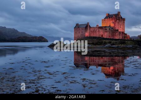 Des spots rouges illuminent le château d'Eilean Donan, Dornie, Kyle de Lochalsh ; Écosse Banque D'Images