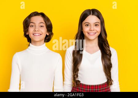 Portrait photo des enfants souriant heureux portant des vêtements décontractés isolés sur fond jaune vif Banque D'Images