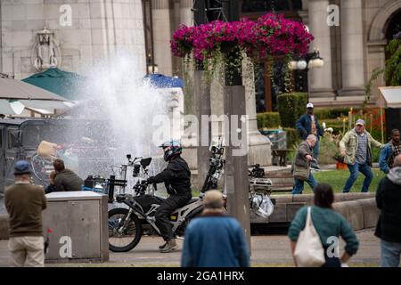 Glasgow, Écosse, Royaume-Uni. 28 juillet 2021. PHOTO : un Humvee s'écrase à travers la fontaine d'eau de George Square dans une scène de marché bondée (illustrée dans le cadre allant de gauche à droite). Des scènes du nouveau film Flash montrant une scène de marché avec une voiture humble se plante à travers une fontaine sur le film situé au centre de Glasgow City Center. La nouvelle superproduction hollywoodienne a choisi le centre-ville de Glasgow pour ses bâtiments à l'aspect américain. Crédit : Colin Fisher/Alay Live News Banque D'Images