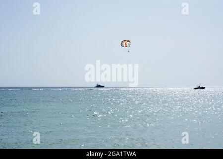 Parachute ascensionnel dans le ciel et au-dessus de la mer des Caraïbes sur la côte de l'île de Cozumel au Mexique Banque D'Images