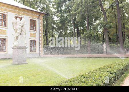 Arrosage automatique des pelouses dans le jardin à côté de la maison. Banque D'Images