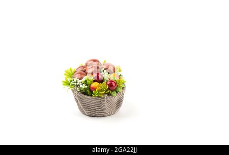 Champignons artificiels et fleurs dans un panier avec toile de jute. Panier de champignons et de lichen de renne sur fond blanc avec place pour le texte. Banque D'Images