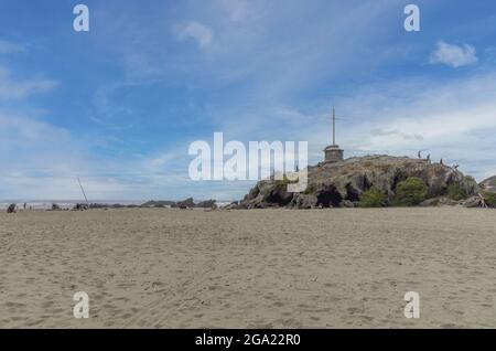 CHRISTCHURCH, NOUVELLE-ZÉLANDE - 19 décembre 2020 : une photo de la plage de Sumner à Christchurch avec un ancien vestige de lave connu sous le nom de Cave Rock en Nouvelle-Zélande. Banque D'Images