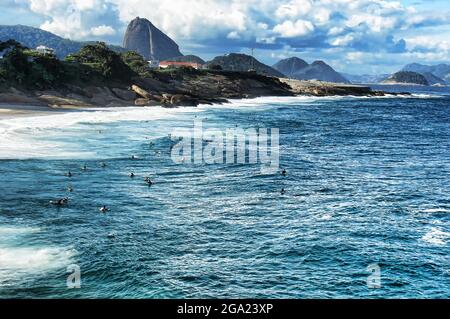 Les surfeurs attrapent une vague sur la plage de Copacabana à Rio de Janeiro Banque D'Images