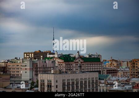 Maisons et toits sur le ciel bleu avec des nuages clairs. Vue panoramique sur le centre-ville de Moscou au coucher du soleil. Tour de télévision d'Ostankino en arrière-plan. Banque D'Images