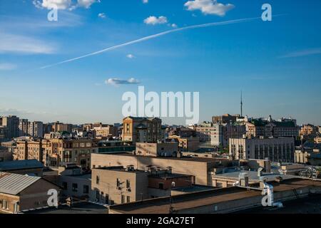 Maisons jaunes et toits sur le ciel bleu avec des nuages clairs. Vue panoramique sur le centre de Moscou au coucher du soleil. Paysage des bâtiments et tour de télévision. Banque D'Images