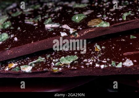 Meilleure tuile de chocolat noir avec pistache. Arrière-plan noir, gros plan. Photo de haute qualité Banque D'Images