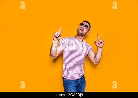 Homme barbu dans des lunettes de soleil pointant le doigt vers le haut Banque D'Images