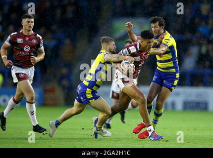 Wigan Warriors Kai Pearce-Paul est affronté par Warrington Wolves Matt Davis (à gauche) et Stefan Ratchford lors du match de la Super League de Betfred au Halliwell Jones Stadium, Warrington. Photo Date: Mercredi 28 juillet 2021. Banque D'Images