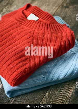 Chandails pliés en rouge et bleu exposés sur une table en bois; Studio Banque D'Images