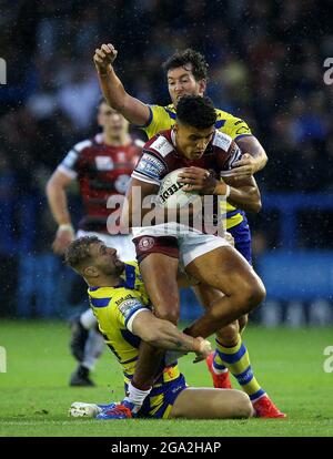 Wigan Warriors Kai Pearce-Paul est affronté par Warrington Wolves Matt Davis (à gauche) et Stefan Ratchford lors du match de la Super League de Betfred au Halliwell Jones Stadium, Warrington. Photo Date: Mercredi 28 juillet 2021. Banque D'Images