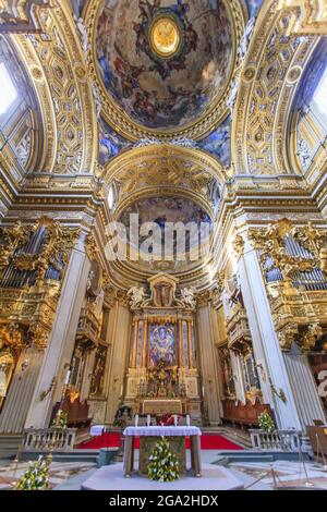 Magnifique intérieur de Sant'Agnese dans l'église catholique d'Agon montrant l'autel principal entouré de fenêtres voûtées dorées et plafond voûté orné au-dessus Banque D'Images