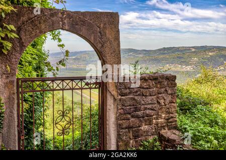 Vue sur la campagne depuis les ruines en pierre avec une porte en fer dans le village historique de Motovun, surplombant les collines de l'Istrie ; Motovun, Croatie Banque D'Images