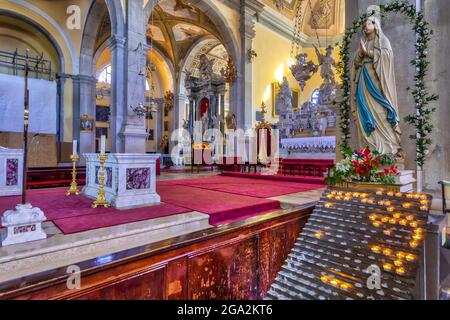 Intérieur de l'église Saint-Euphemia, montrant une statue religieuse et des bougies allumées pour prières et intentions avec un autel principal élaboré dans la ... Banque D'Images