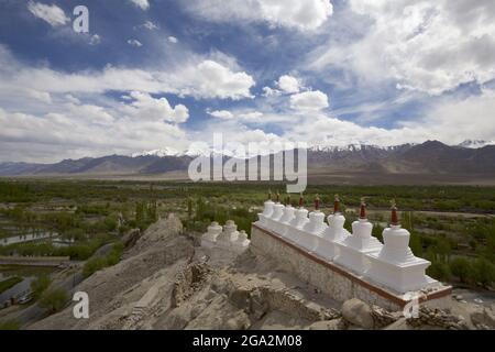 Stupas bouddhistes blanchis à la chaux (connus sous le nom de chortens dans la culture tibétaine) dans une rangée sur un sommet de montagne aux ruines du monastère de Shey au-dessus du Val d'Indus... Banque D'Images
