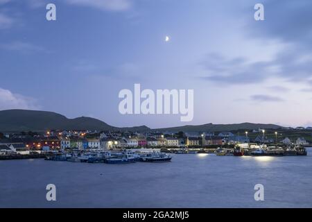 La petite ville de Portmagee et le port au crépuscule avec le quart de lune dans le ciel; Portmagee, comté de Kerry, Irlande Banque D'Images