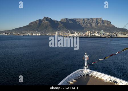 Gros plan de l'arc d'un navire dans la baie de Table en regardant vers le port de Cape Town et le majestueux Devil's Peak et la montagne de Table qui s'élève au-dessus de la ... Banque D'Images