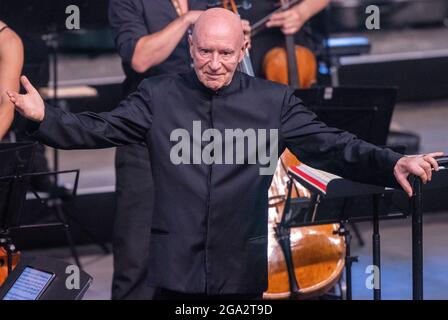 Redefin, Allemagne. 24 juillet 2021. Christoph Eschenbach dirige l'Orchestre de Chambre de Zurich dans la salle d'équitation de la bourse d'État Mecklembourg-Poméranie-Occidentale. Après la pause forcée de l'année dernière due à la corona, les concerts du festival auront lieu de nouveau en vertu des règlements de protection de la corona. Au total, quatre concerts seront donnés dans la salle d'équitation de la ferme classique de Stud ce week-end. Un maximum de 1250 auditeurs sont admis. Avant le concert, il y avait le traditionnel pique-nique en plein air et un spectacle de chevaux à regarder. Credit: Jens Büttner/dpa-Zentralbild/ZB/dpa/Alay Live News Banque D'Images