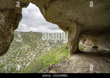 Vue depuis la grotte le long des sentiers à travers la rivière Gravina di Matera et le parc près de Matera; Matera, Basilicate, Italie Banque D'Images