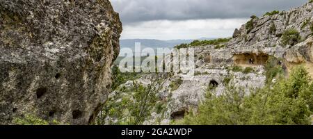 Vue sur les falaises rocheuses et les grottes le long des sentiers à travers la rivière Gravina di Matera et le parc près de Matera; Matera, Basilicate, Italie Banque D'Images