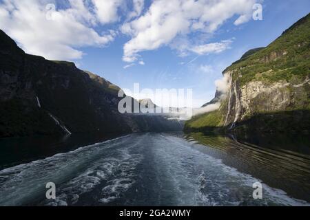 Vue sur la cascade de Seven Sisters avec des nuages brumeux qui pendent sur la voie navigable tout en naviguant dans le Geirangerfjord de Sunnmore, long de 15 km Banque D'Images