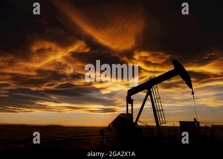 Silhouette d'une citrouille contre un ciel spectaculaire et coloré et des nuages au coucher du soleil, à l'ouest d'Airdrie; Alberta, Canada Banque D'Images