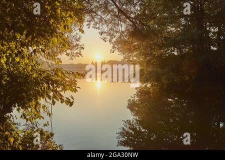 Lever du soleil au lac de Wohrder Voir encadré par le feuillage sur les arbres, près de Nuremberg; Franconie, Bavière, Allemagne Banque D'Images